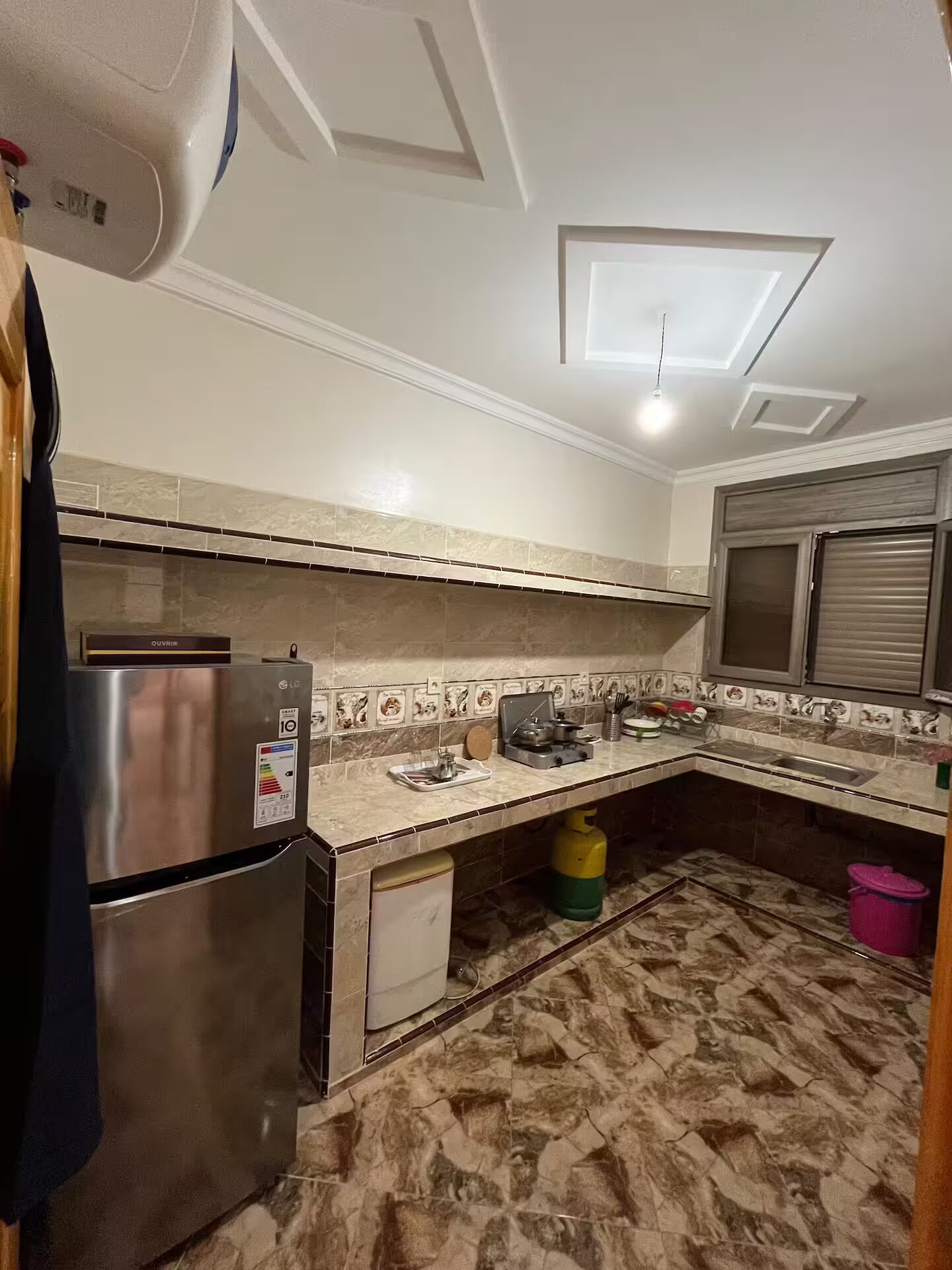 A kitchen with a stainless steel refrigerator, a gas stove, and a microwave.