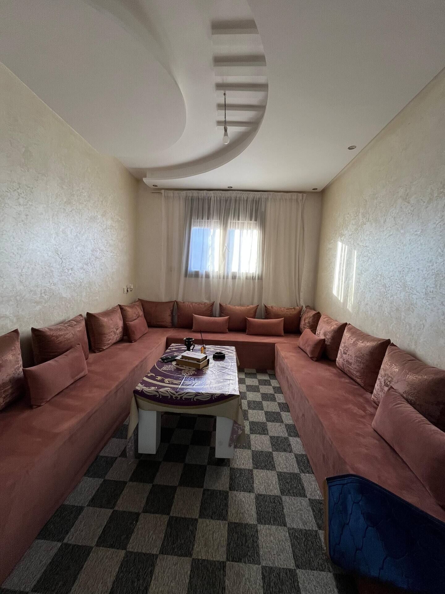 A living room with a checkered floor, a sofa set, and a coffee table.