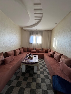 A living room with a checkered floor, a sofa set, and a coffee table.