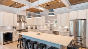 A modern kitchen with a large island, stainless steel appliances, and bar stools. - Seagrove - Sleeps 13 - Private Pool- Near Seaside (Santa Rosa Beach)