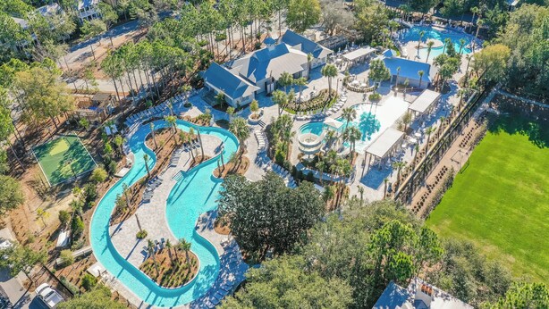 Vista aérea de um resort com várias piscinas, áreas de estar e um toboágua.