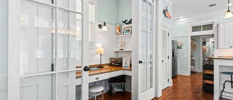 Una cocina con armarios blancos, encimera de madera y estufa empotrada.