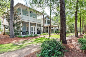A two-story house with a porch, surrounded by trees and a well-maintained lawn. - Watercolor - Watercolor Amenity Passes - Sleeps 8 (Santa Rosa Beach)
