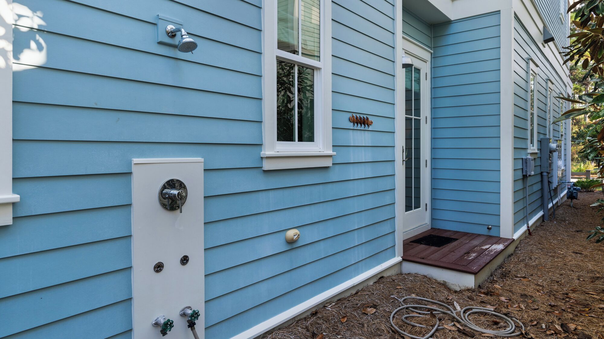 A blue house with a front door, a small window, and a mailbox.