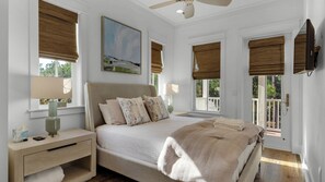 A bedroom with a large bed, two bedside tables, a ceiling fan, and a painting on the wall. - Access to Watercolor Pools & Beach Club - 4-bedroom Beach Oasis - Sleeps 12 (Santa Rosa Beach)
