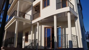 Un edificio de varios pisos con balcones, ventanas amplias y cielo despejado.