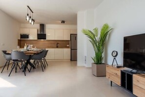 Relax in a contemporary living space with a dining area, flat-screen TV, and kitchenette.
