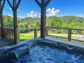 A hot tub with a wooden deck and a view of a forested landscape. - Logged Out: Mountain Cabin w/ Hot Tub, Arcade & Game Room, River Access (Piney Creek)