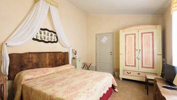 Une chambre à coucher comprenant un lit, une armoire, un téléviseur et un bureau.