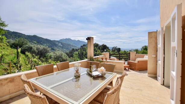 A terrace with wicker furniture, a glass table, and a view of mountains. - 3 bedroom lovely home in Pietrasanta (Pietrasanta)