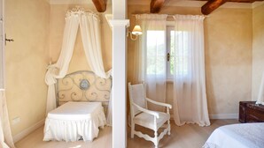 A bedroom with a canopy bed, a white chair, a wooden chest, and a window with curtains. - 3 bedroom lovely home in Pietrasanta (Pietrasanta)