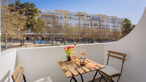 A balcony with a table set for two, a bottle of wine, and a book.