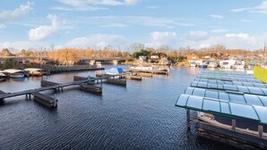 Una vía fluvial tranquila con barcos amarrados y un puente al fondo.