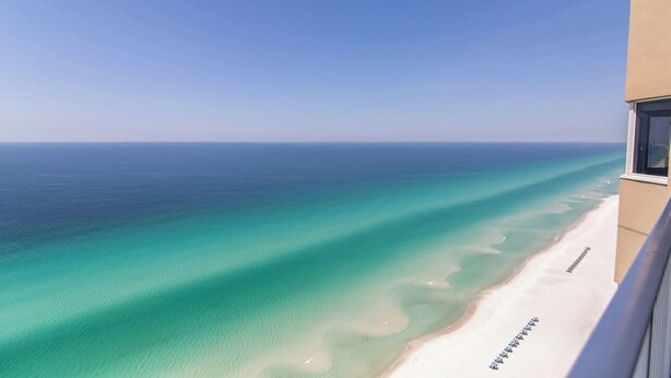 Una vista despejada de una playa con aguas turquesas y una orilla de arena blanca.