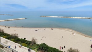 A beach with people sunbathing and walking along the shore. - Elegante Appartamento con Spiaggia sul Mare di Bari (Bari)