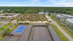 A multi-story hotel with a parking lot, tennis court, and a view of a lake. - ~ Beach Breeze ~   Beautiful Oceanfront 3 Bed/2 Bath Condo (Myrtle Beach)