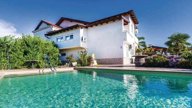 A two-story building with a swimming pool in front.