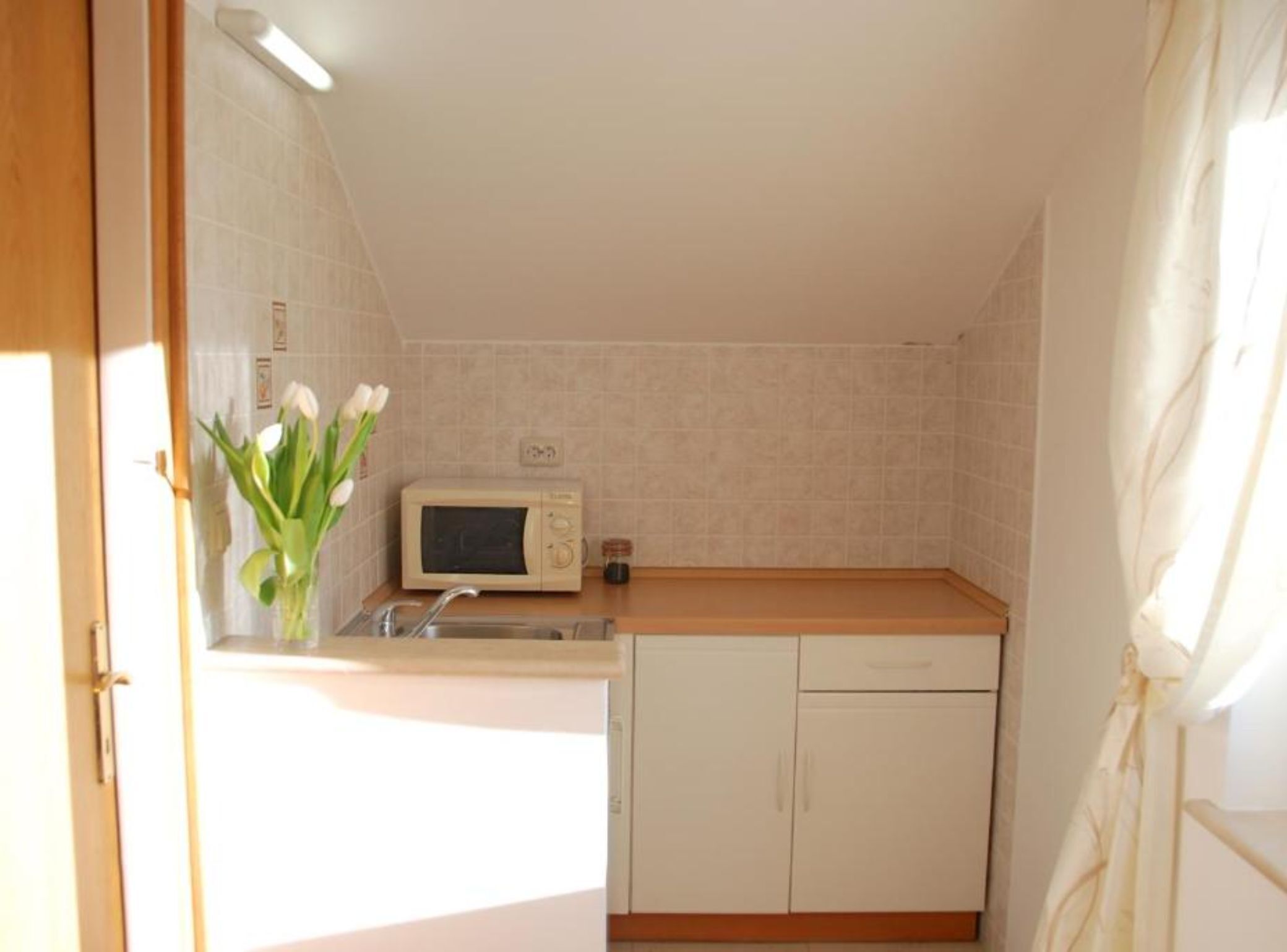 A small kitchen with a microwave, sink, and cabinets.