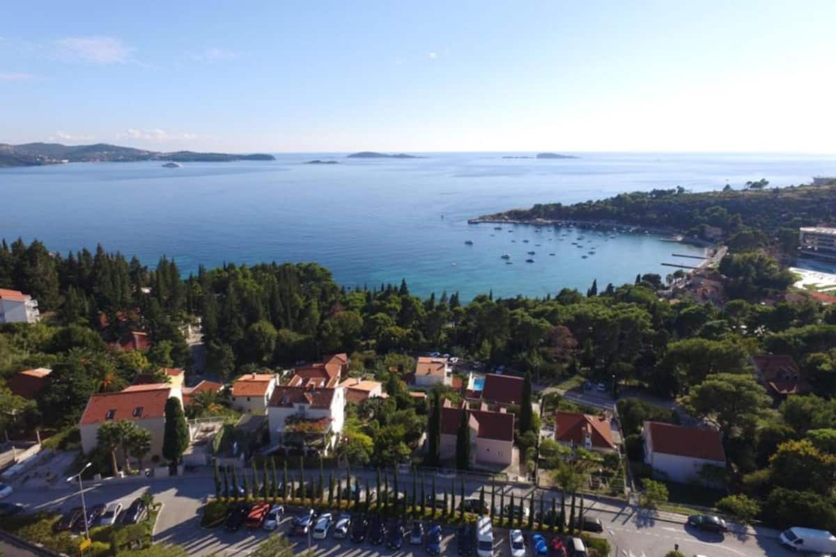 A coastal town with buildings, a road, and a marina with boats.