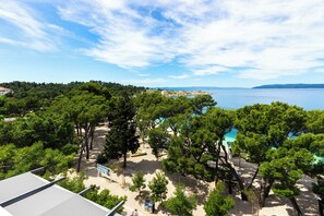 A beach with trees, a pool, and a view of the sea. - Luxury Penthouse Apt on beach Makarska (Makarska)