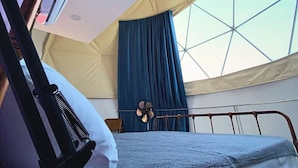 A tented room with a bed, a fan, and a window. - AmanDagat Beach Resort (San Felipe)