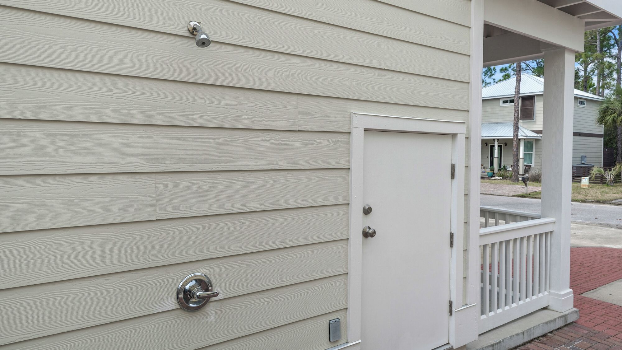A house with a white exterior, a front door, and a small porch with a railing.