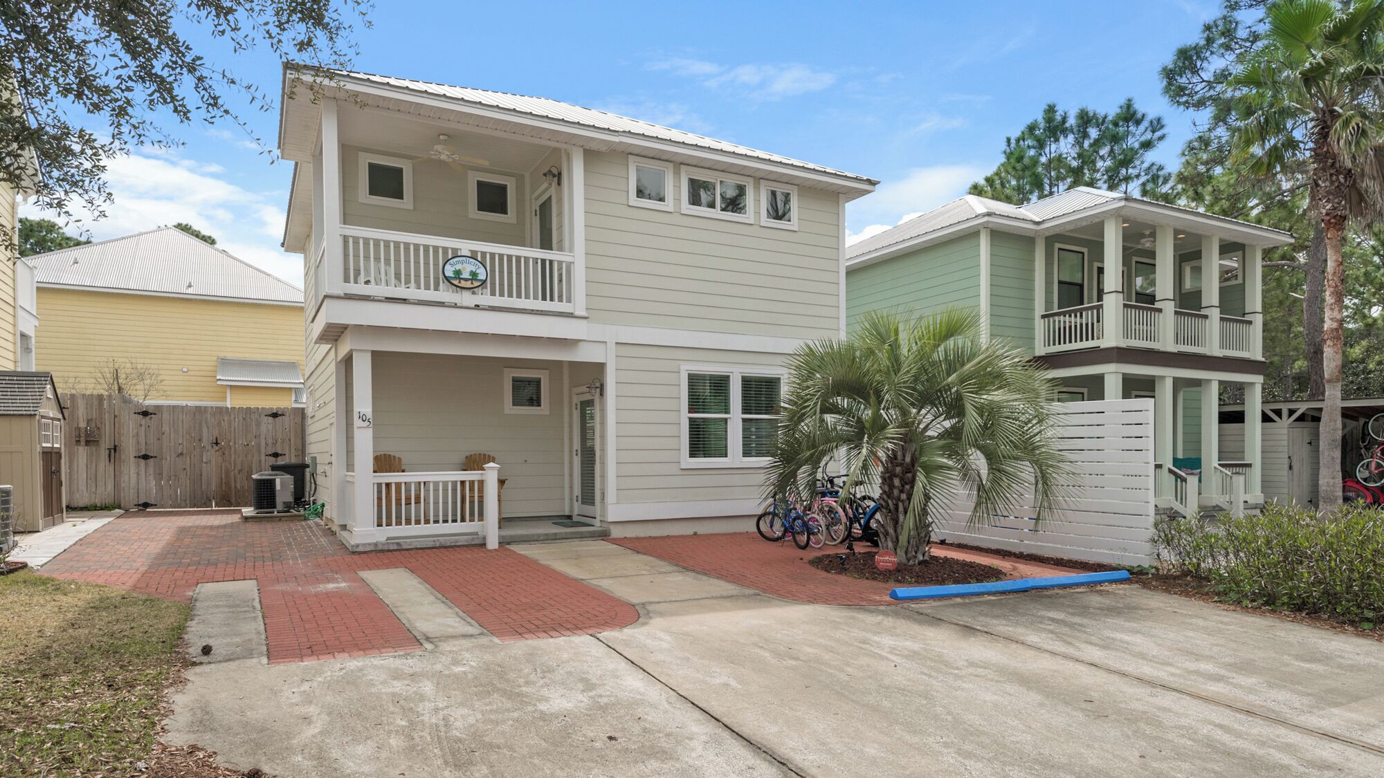 A two-story house with a front porch, a small garden, and a garage.