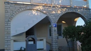 Edifici amb arcs de pedra i un cartell blau.