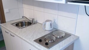 Cuina compacta amb rentatall, i bullidor i dos fogons elèctrics.