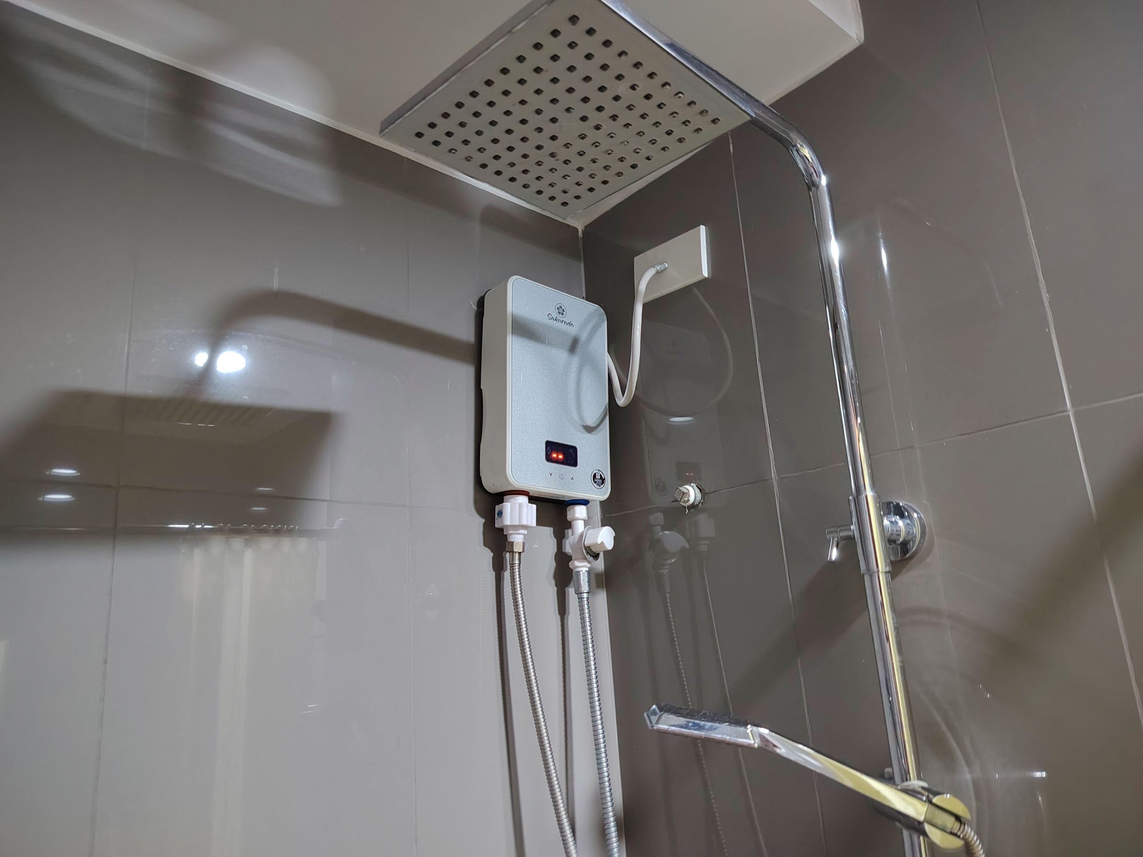 Et bruseområde med kontrolpanel, håndbruser og brusearmatur i loftet.