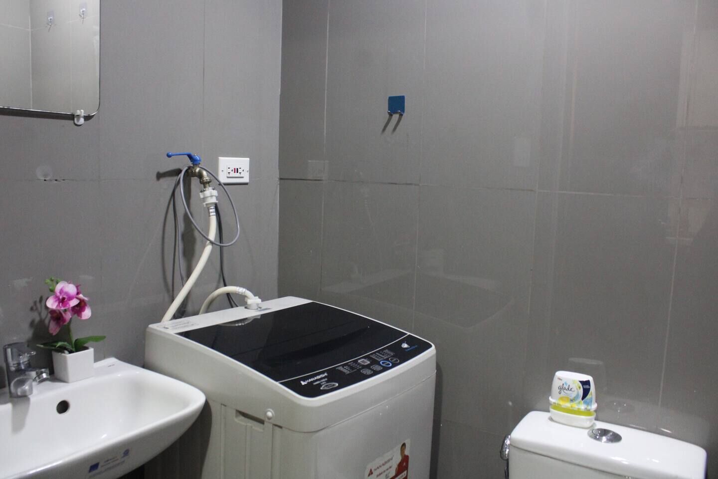 A bathroom with a white sink, a toilet, and a wall-mounted heater.