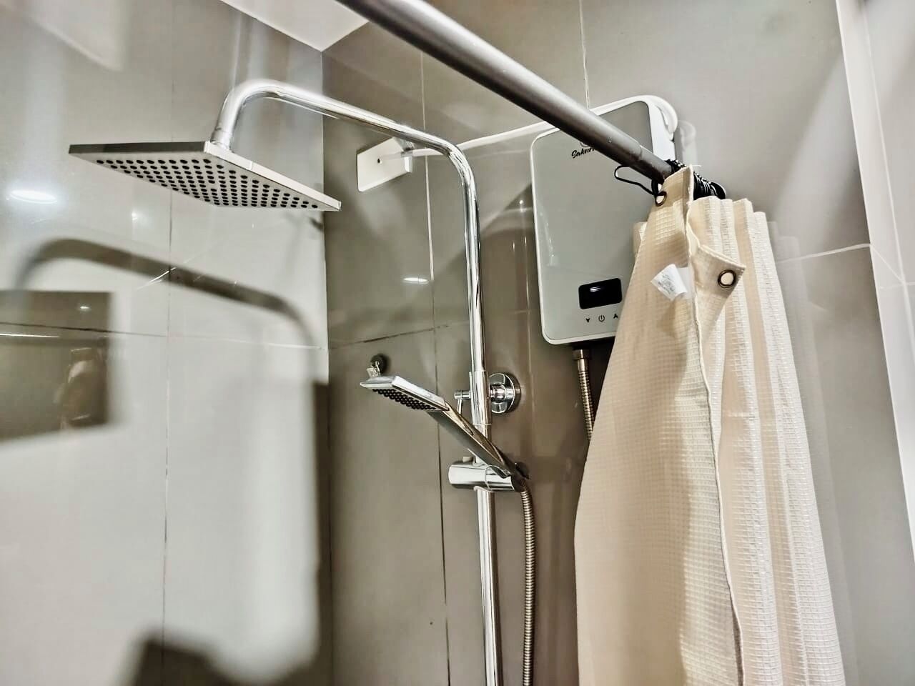 Un baño con ducha, toallero y panel de control.