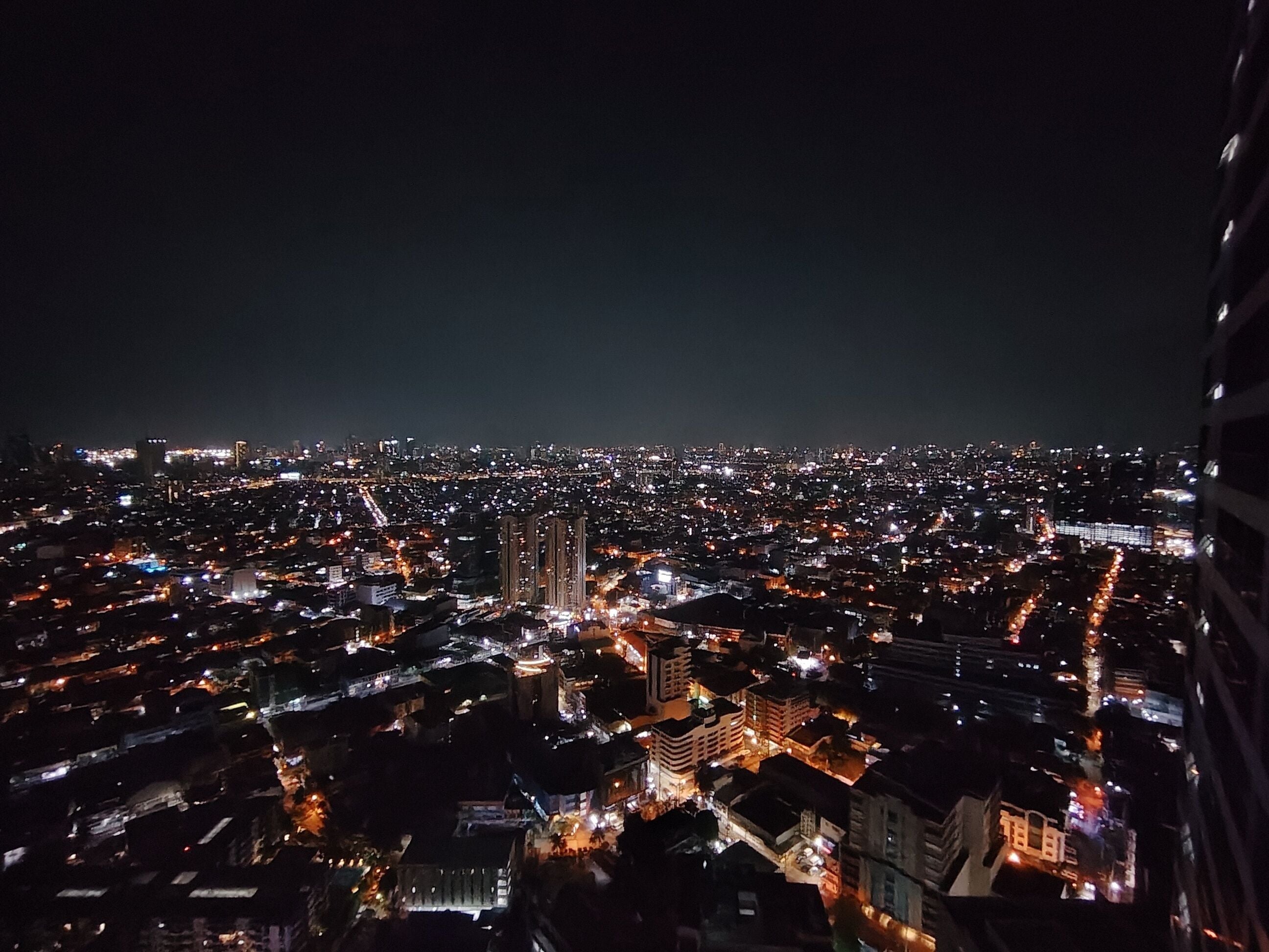 A nighttime cityscape with illuminated buildings and streets.