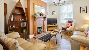 A living room with a fireplace, a television, and comfortable seating.