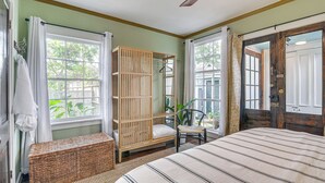 Un dormitorio con cama, un armario de madera, un banco y una silla.