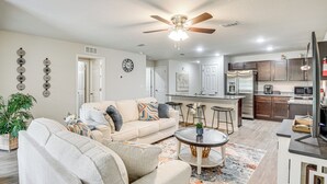 A modern living room with a sofa, coffee table, and decorative wall art. - Palm Coast Duplex w/ Screened Patio, Near Beaches! (Palm Coast)