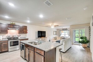 A modern kitchen with granite countertops, stainless steel appliances, and wooden cabinets. - Palm Coast Duplex w/ Screened Patio, Near Beaches! (Palm Coast)