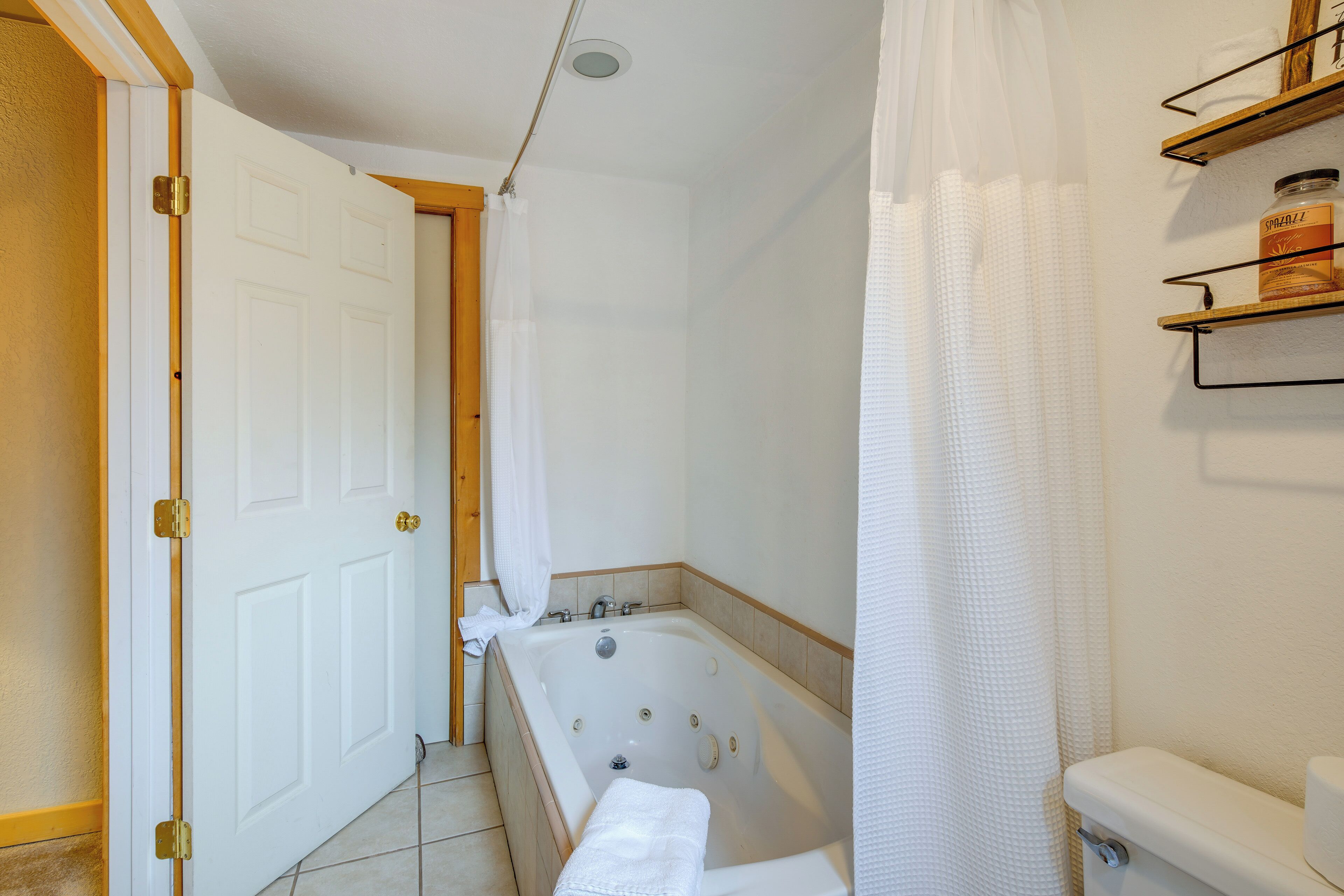 A bathroom with a bathtub, toilet, and shower curtain.