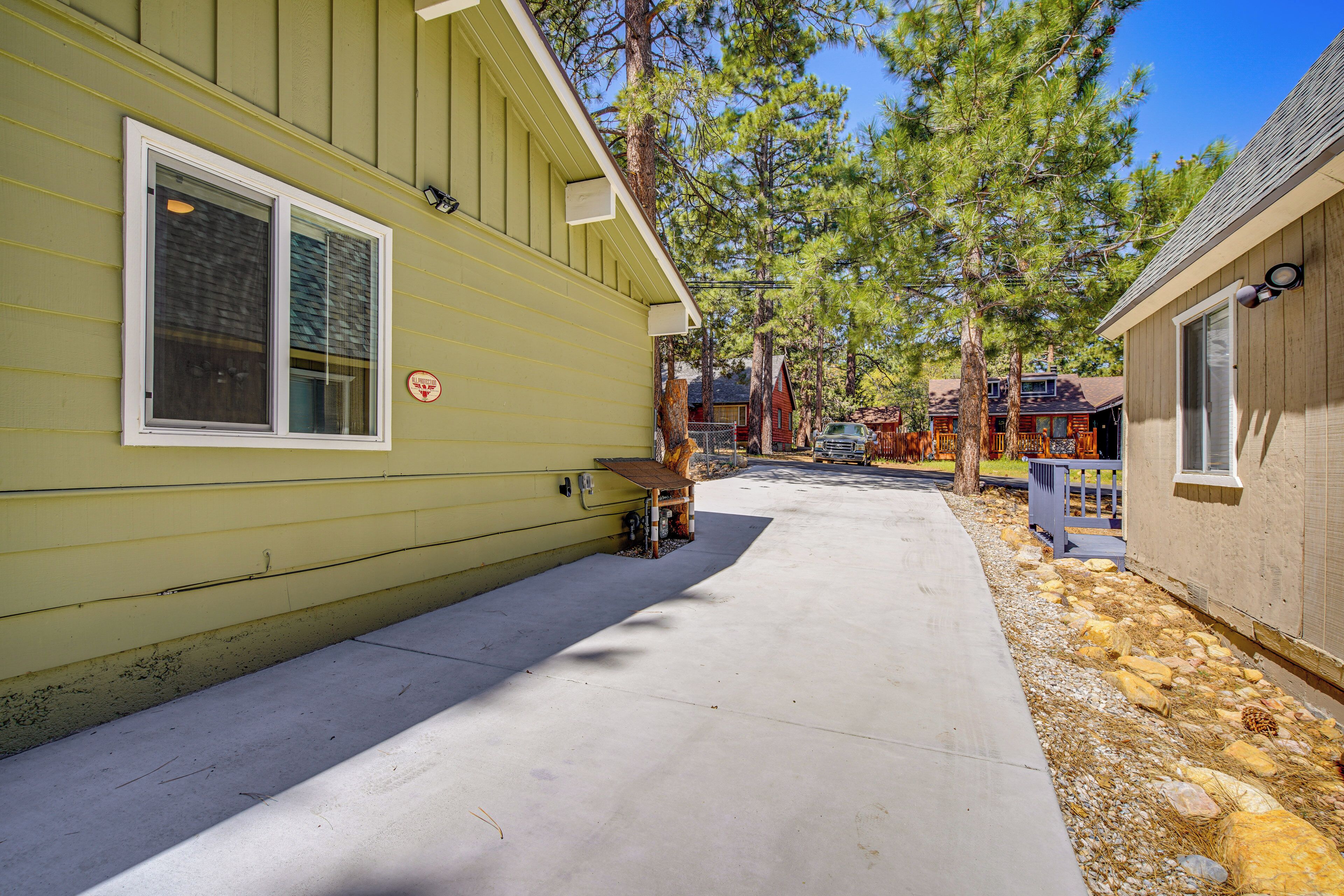 A yellow building with a concrete pathway leading to a wooden deck.