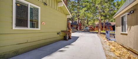 A yellow building with a concrete pathway leading to a wooden deck.