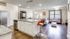 A modern kitchen with white cabinetry, a granite countertop, and stainless steel appliances. - Lawrenceville Townhome w/ Community Pool Access! (Lawrenceville)