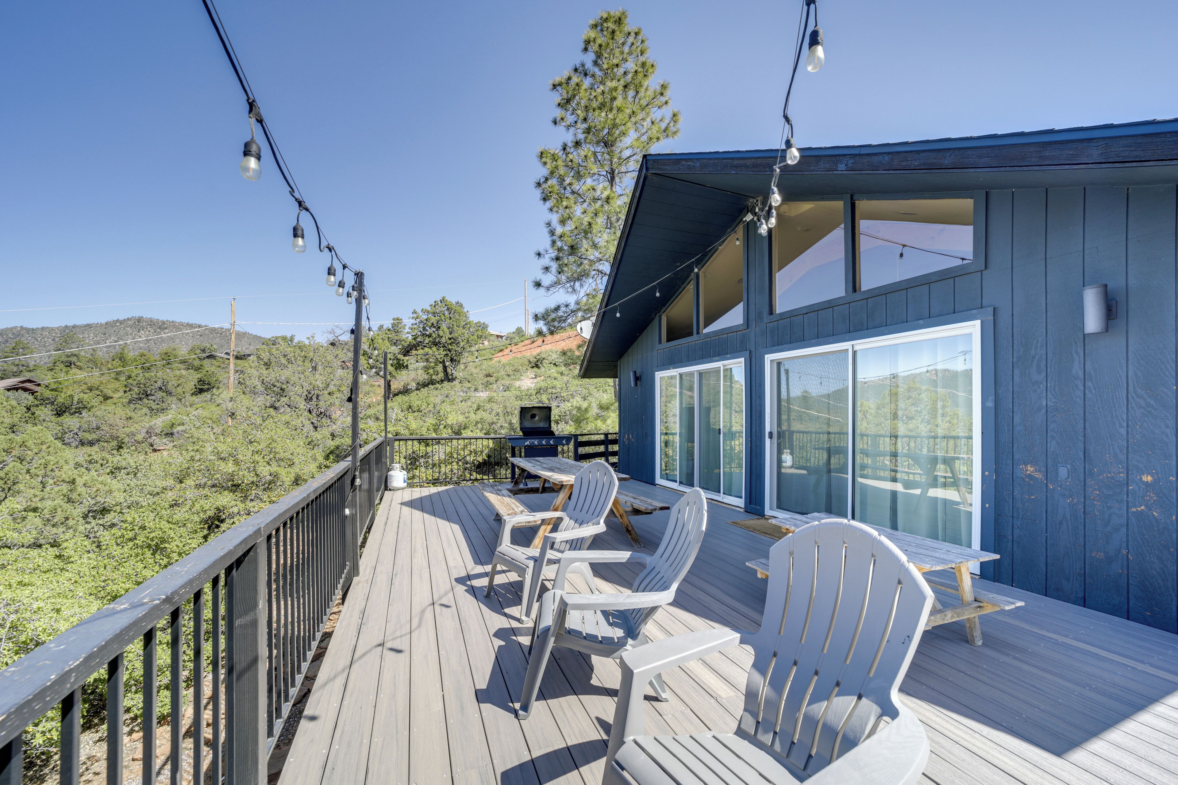 A deck with outdoor seating and a view of the surrounding landscape.
