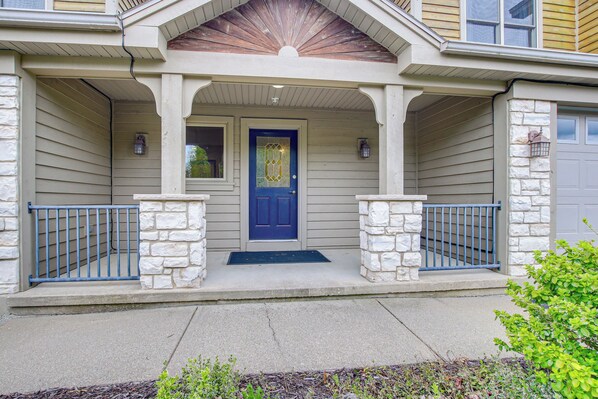 A house with a blue door, stone pillars, and a covered porch. - Door County Townhome: Pool Access, 1 Mi to Beach! (Egg Harbor)