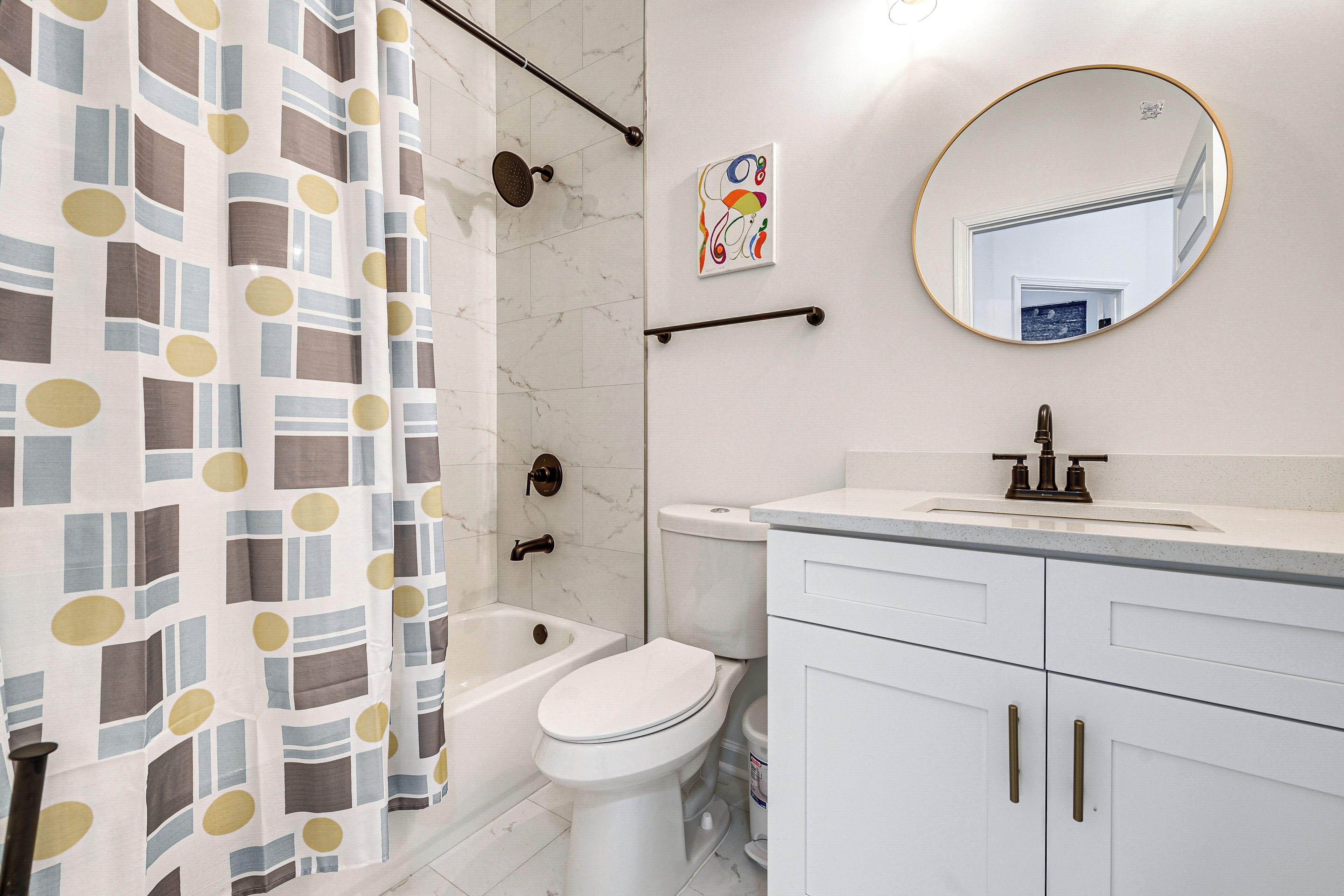A bathroom with a shower, toilet, and sink.