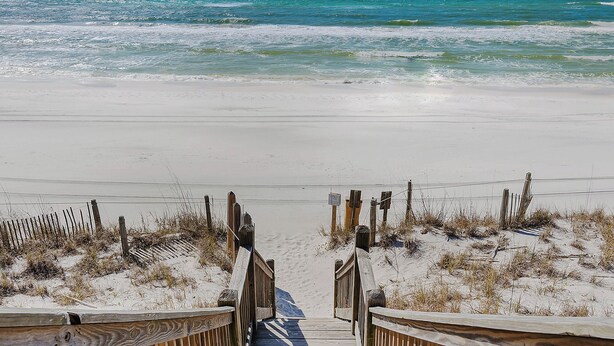 A wooden staircase leading down to a sandy beach with a view of the ocean. - Beautiful Original Seaside Cottage + Swim & Tennis Club: Sleeps 6 (Santa Rosa Beach)
