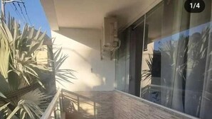 A balcony with a tiled floor, a metal railing, and a glass door. - Pousada Paraiso Barra da Tijuca (Rio de Janeiro)