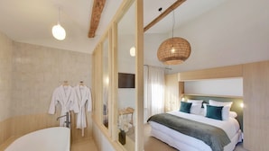 A modern bathroom with a freestanding bathtub, a large mirror, and a wooden ceiling. - La Maison Gaïa Hôtel & Spa (Torreilles)