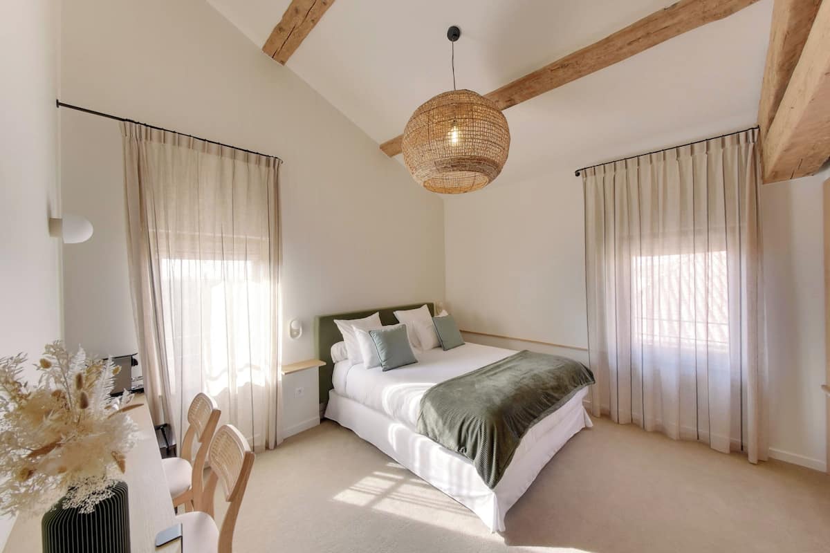 Un dormitorio con una cama, un escritorio y una silla, y un candelabro colgante.