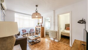 Een woonkamer met een bank, salontafel en een hanglamp.