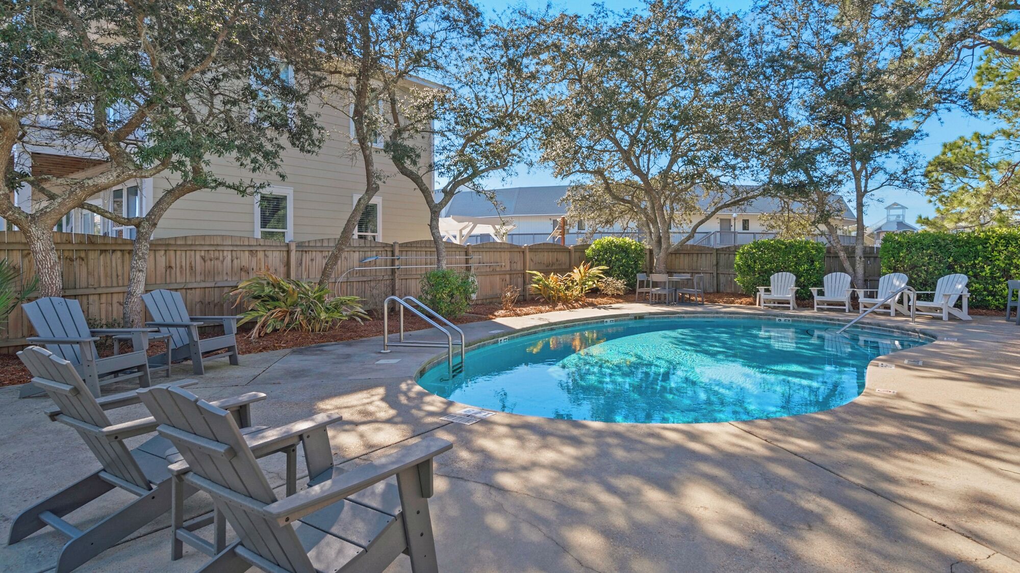 A swimming pool with lounge chairs and a wooden deck.